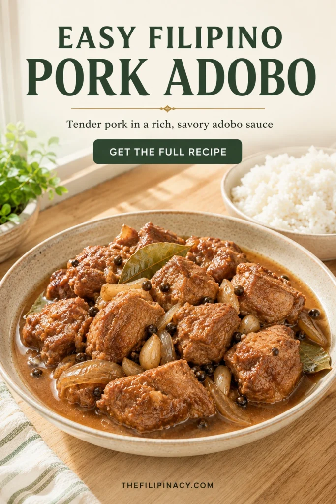 Easy Filipino pork adobo with tender browned pork in a savory adobo sauce, served with white rice on a light wood table.